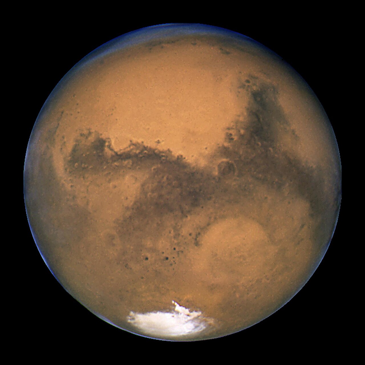 Mars, an orange-red planet with a white polar cap
